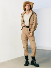 A lady wears cargo pants and boots.